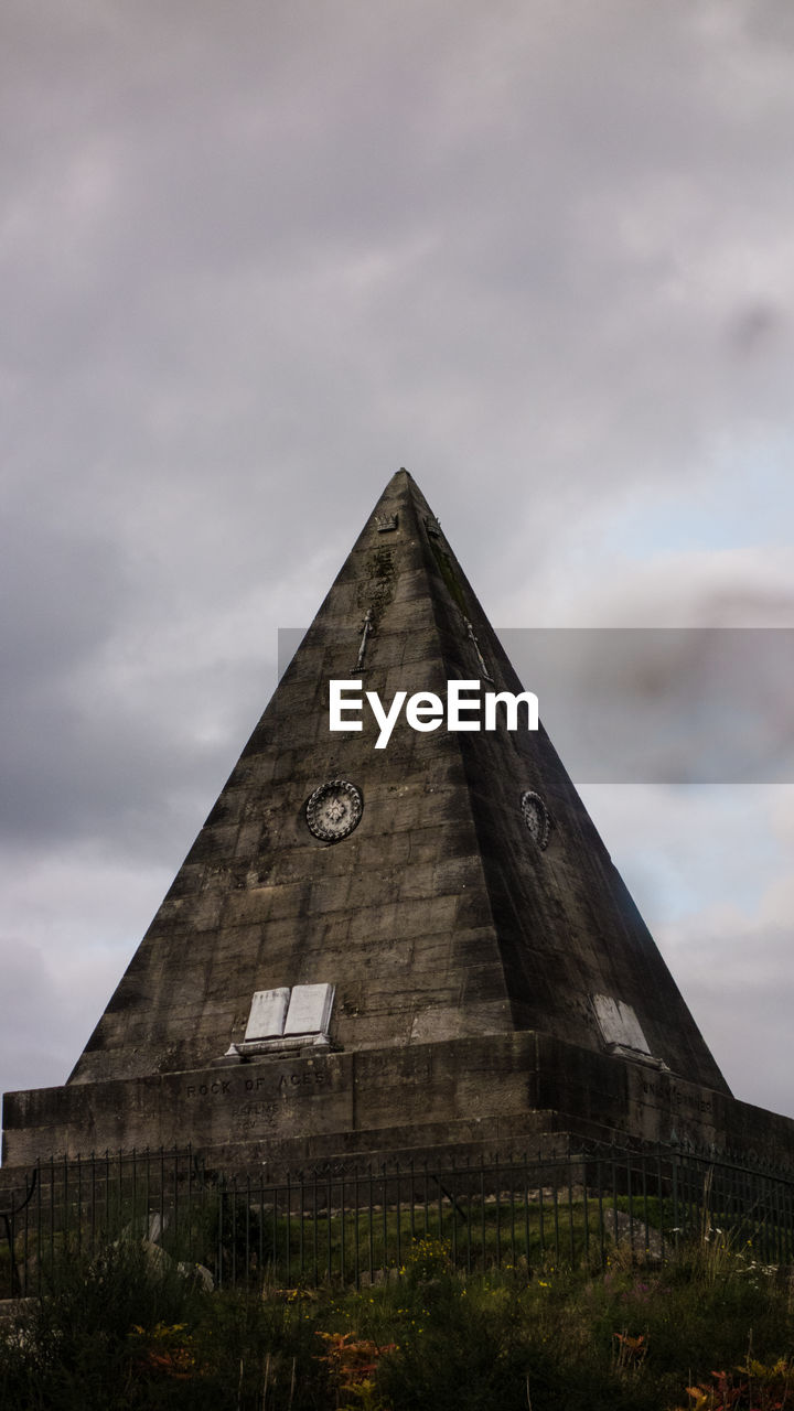 Low angle view of star pyramid against cloudy sky