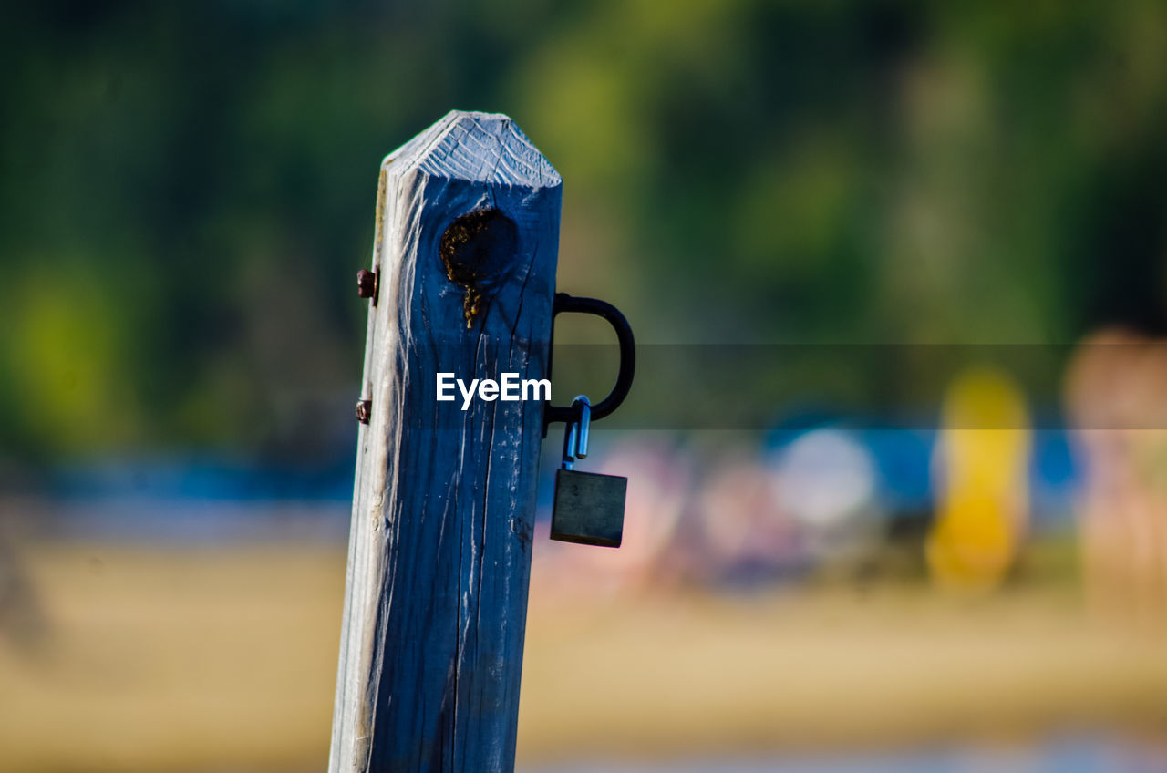 CLOSE-UP OF PADLOCK HANGING ON WOOD