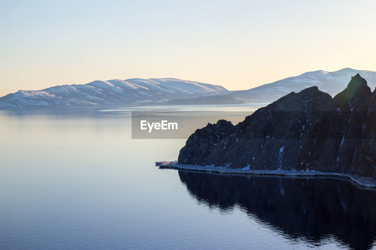 Scenic view of lake and mountains against clear sky