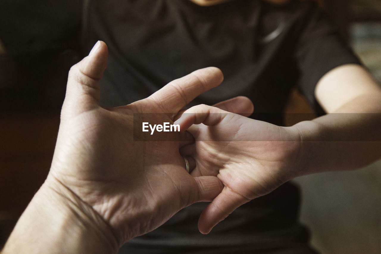 Father and son locking fingers at home