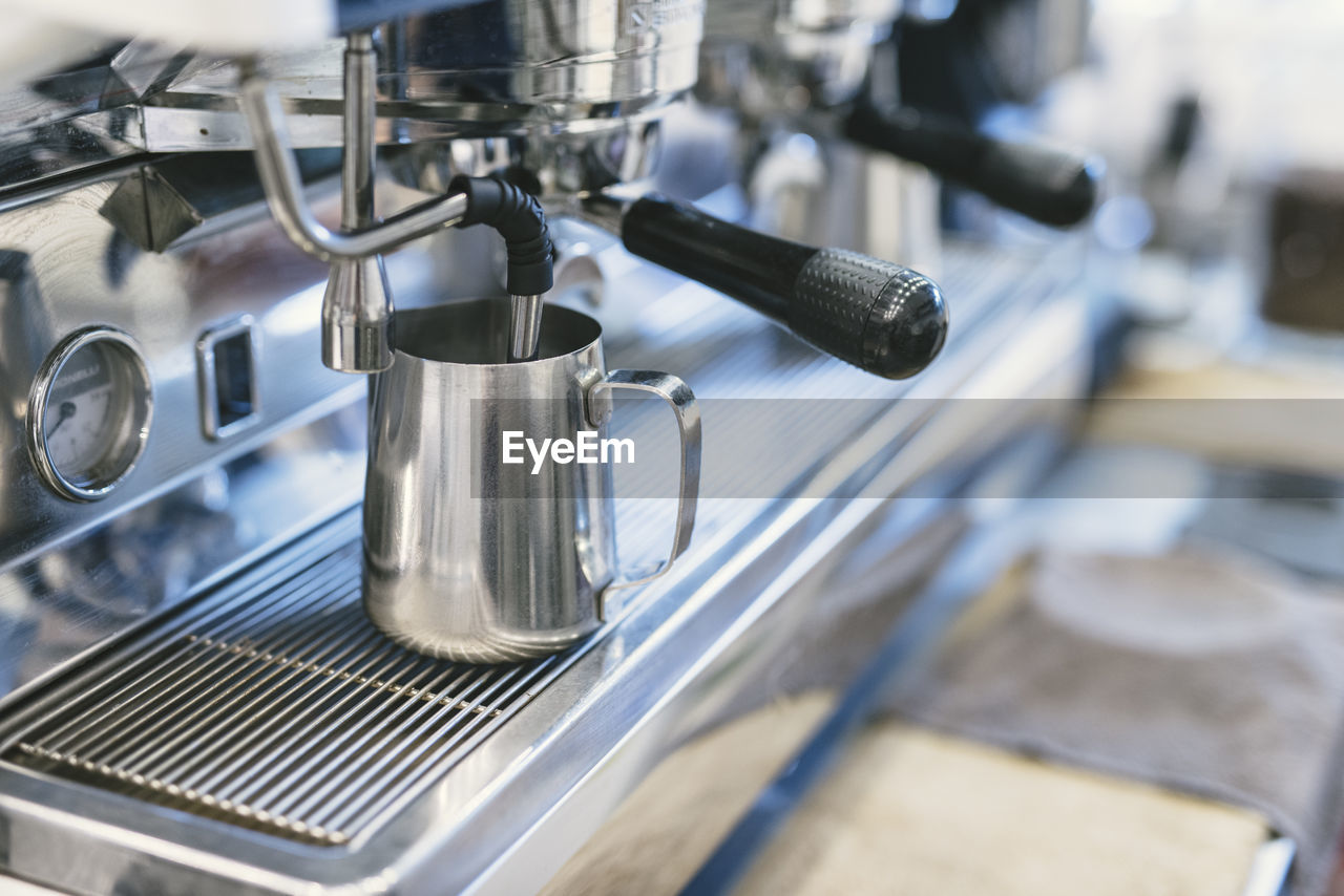 High angle view of pitcher in espresso maker at cafe