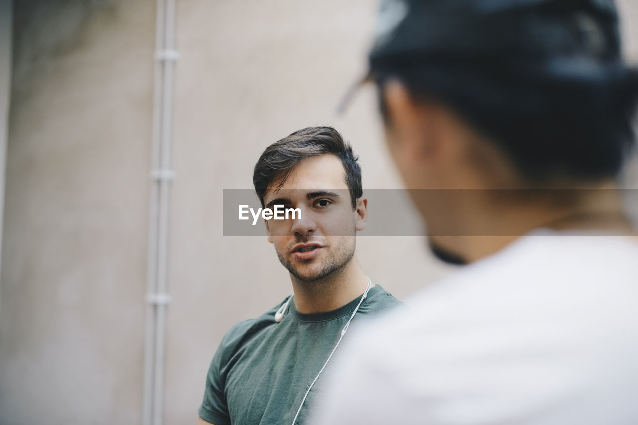 Male computer programmer talking to male colleague in office