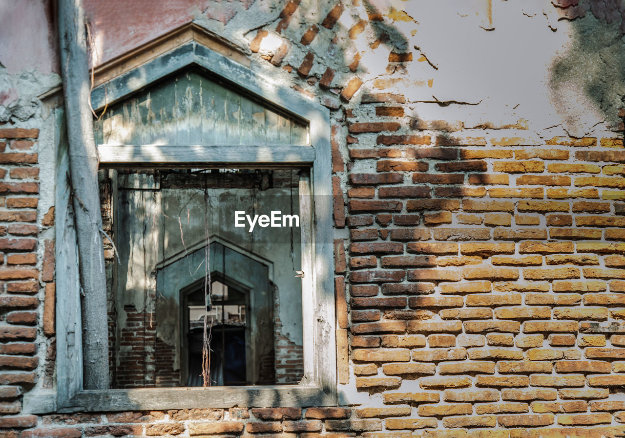 LOW ANGLE VIEW OF OLD WINDOW ON BUILDING