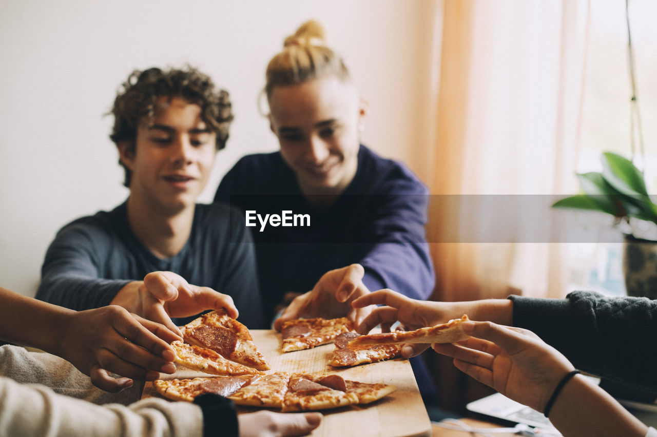 PEOPLE LOOKING AWAY WHILE SITTING AT TABLE