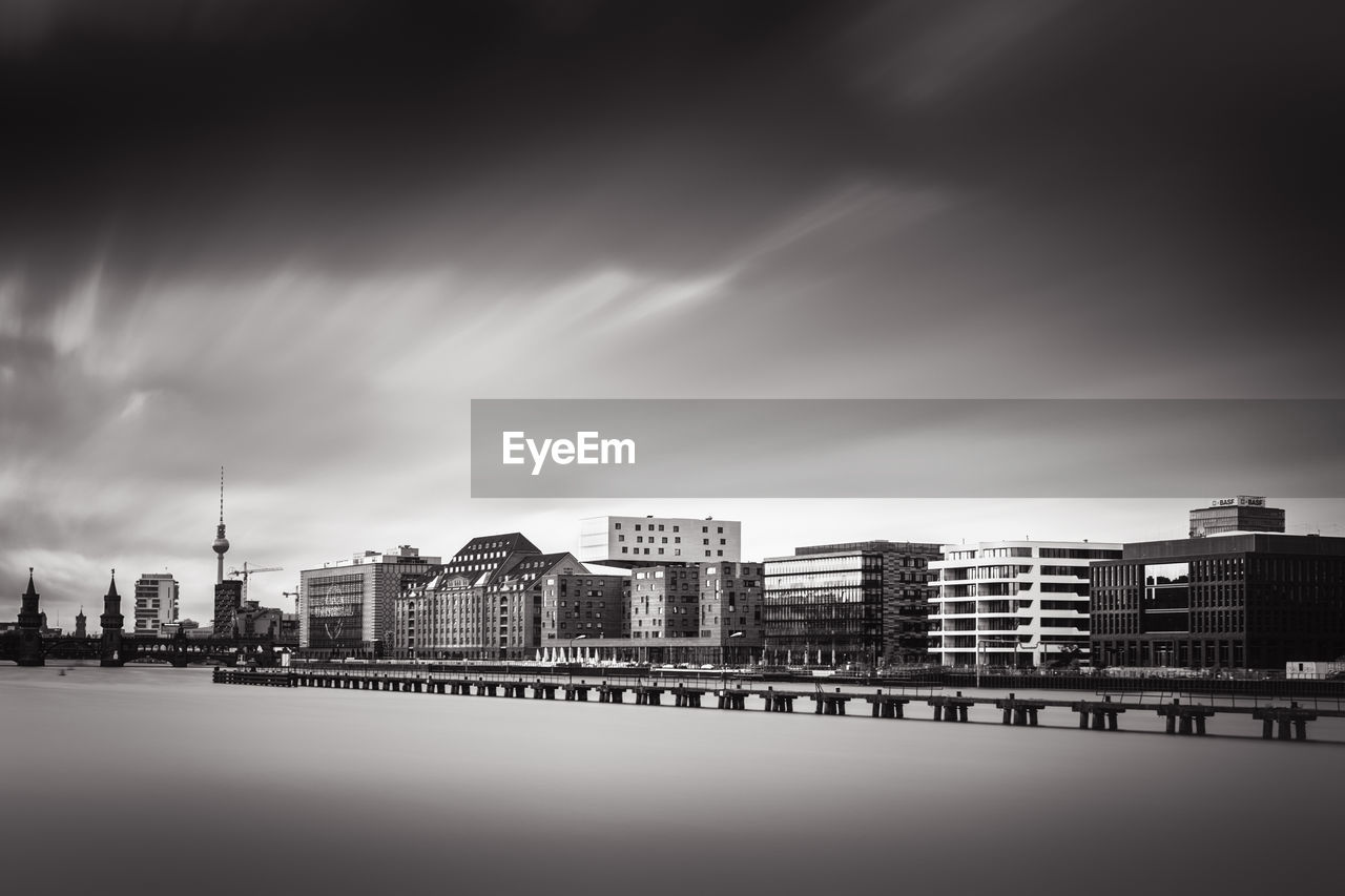 Buildings in city against cloudy sky