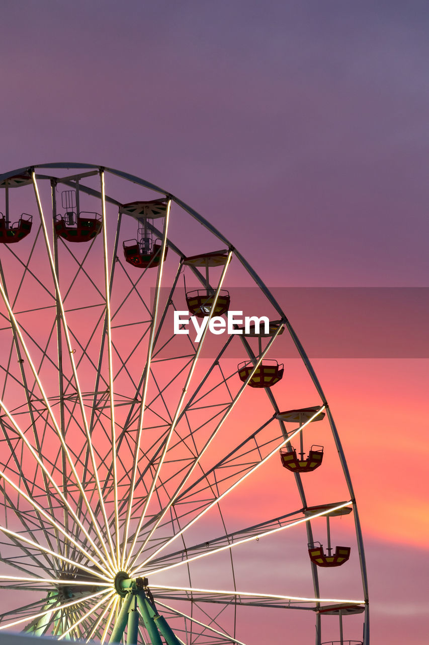 Low angle view of ferris wheel against sky during sunset