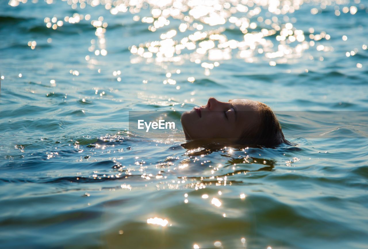 Side view of young woman swimming in sea
