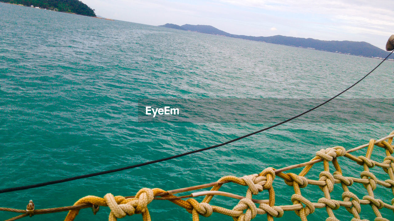 High angle view of rope at sea against mountain