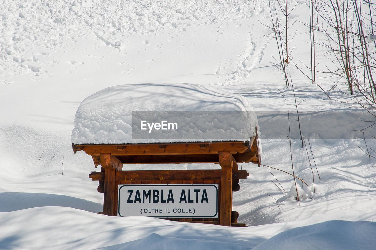 TEXT ON SNOW COVERED FIELD AGAINST MOUNTAIN