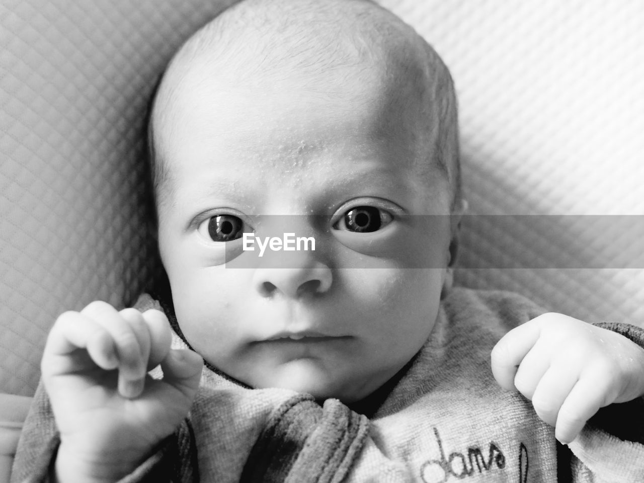 High angle portrait of cute baby boy lying on bed