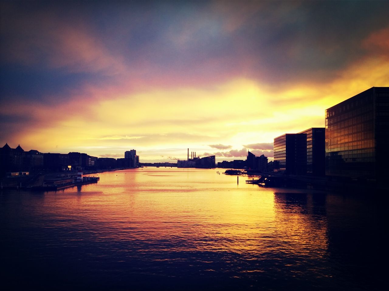 Lake and buildings against dramatic sky