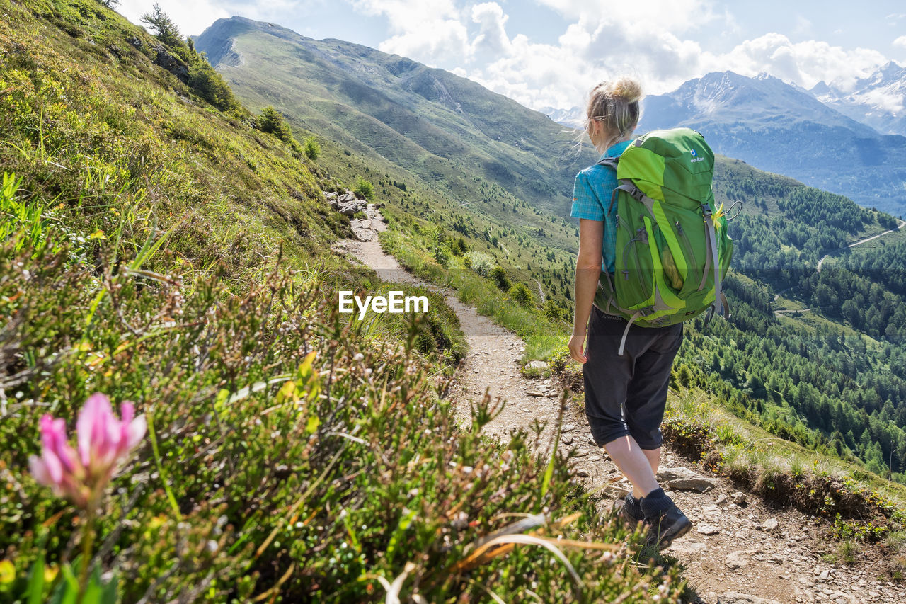 REAR VIEW OF HIKER ON MOUNTAIN