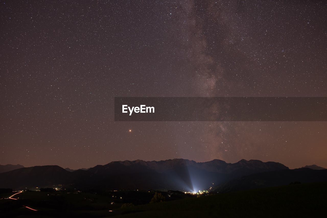 Scenic view of mountains against sky at night