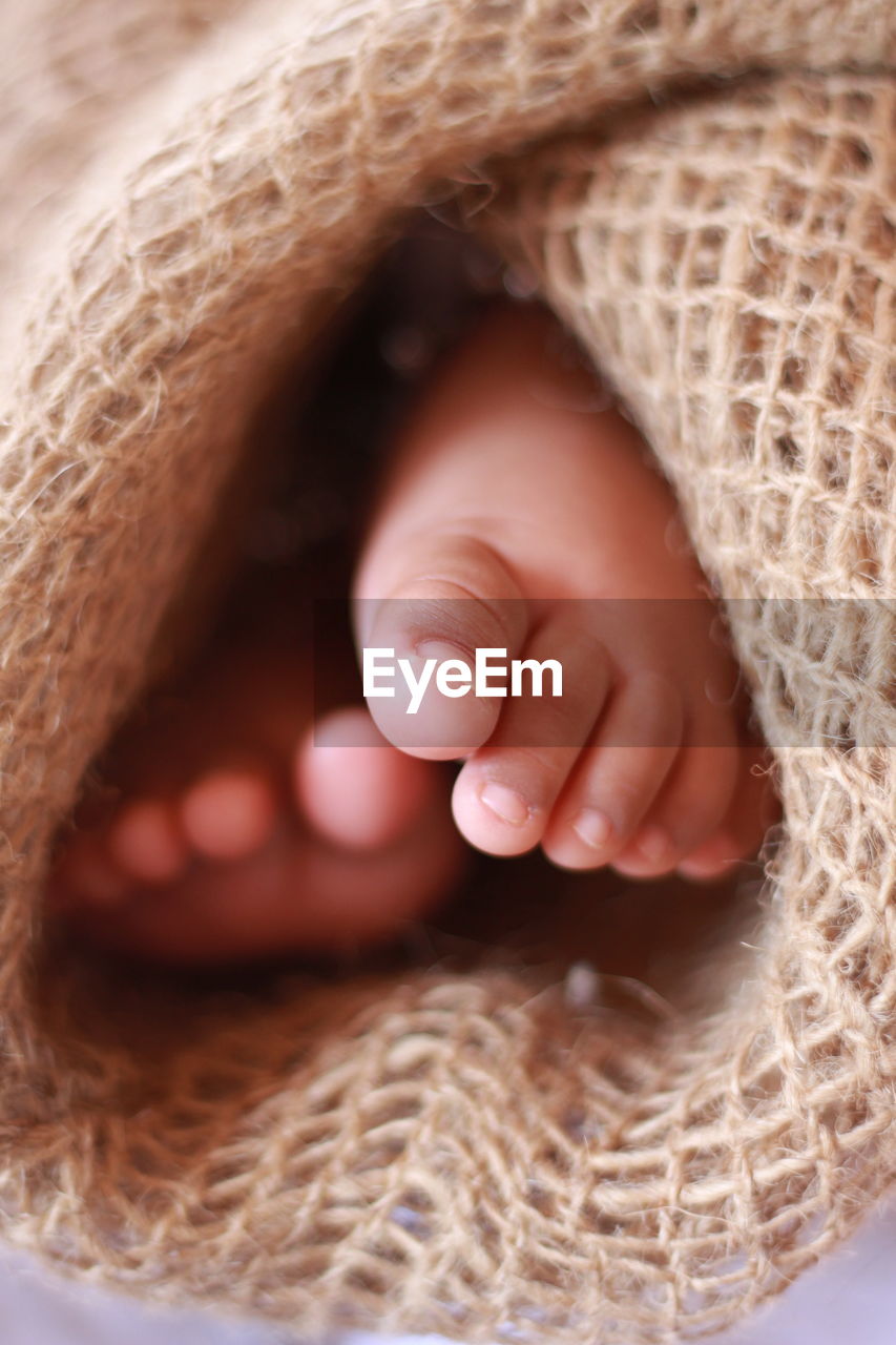 Low section of baby wrapped in burlap