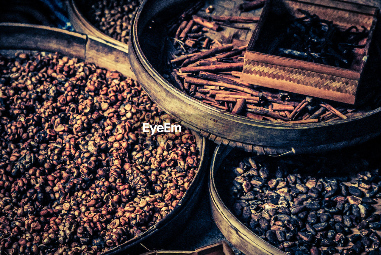 CLOSE-UP OF COFFEE BEANS IN FRONT OF OLD BUILDING