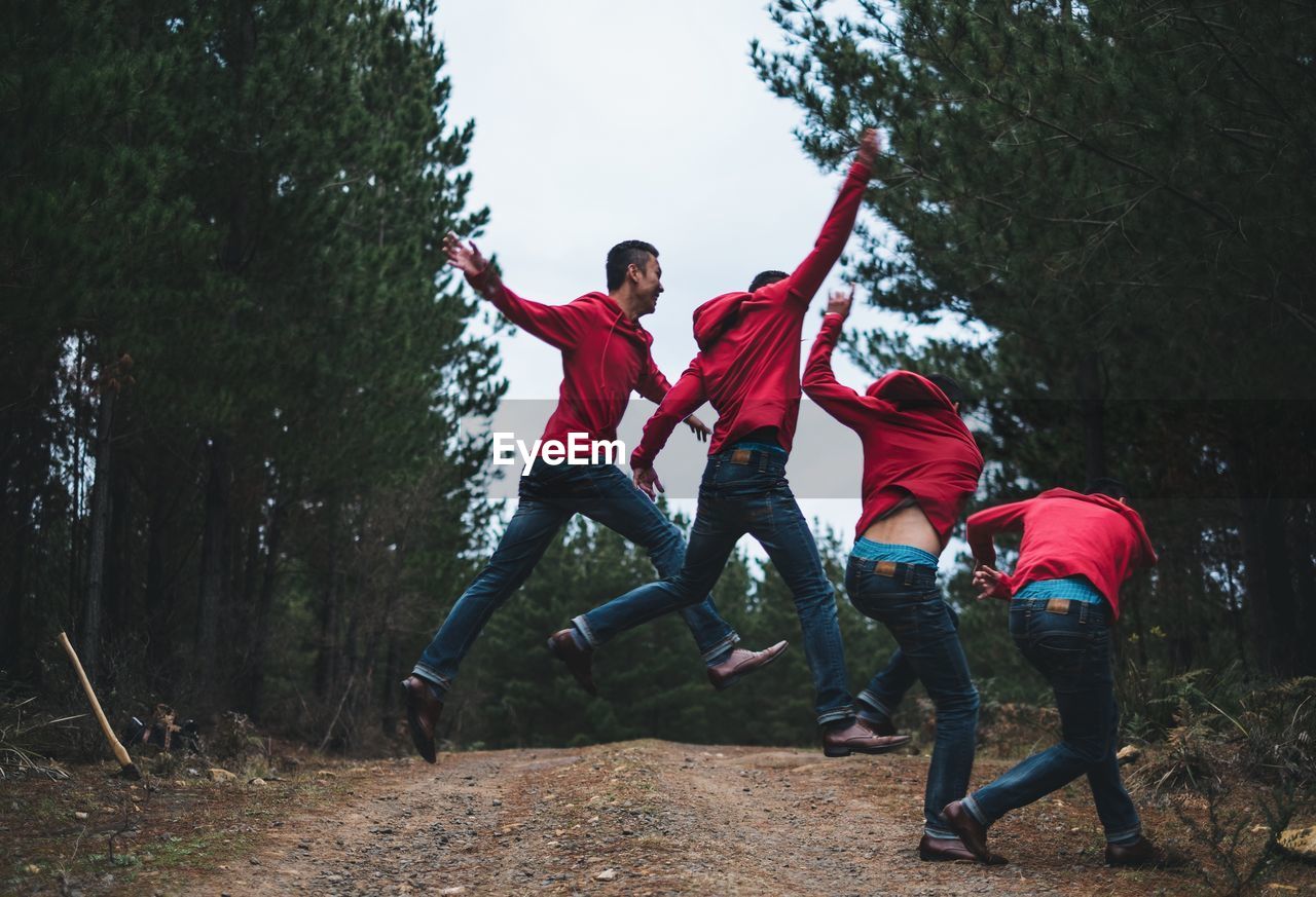 Multiple exposure of young man jumping on dirt road in forest