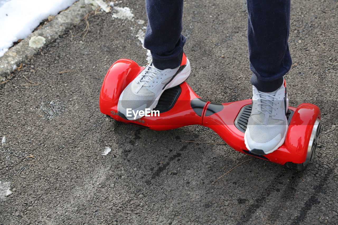 Low section of man riding segway on road