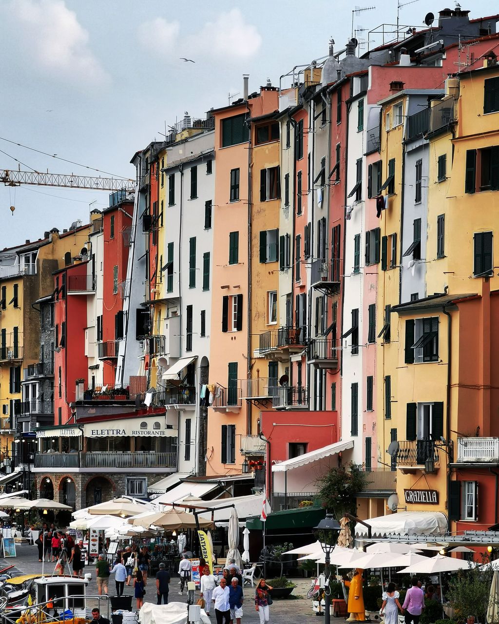 PEOPLE ON STREET BY BUILDINGS AGAINST SKY