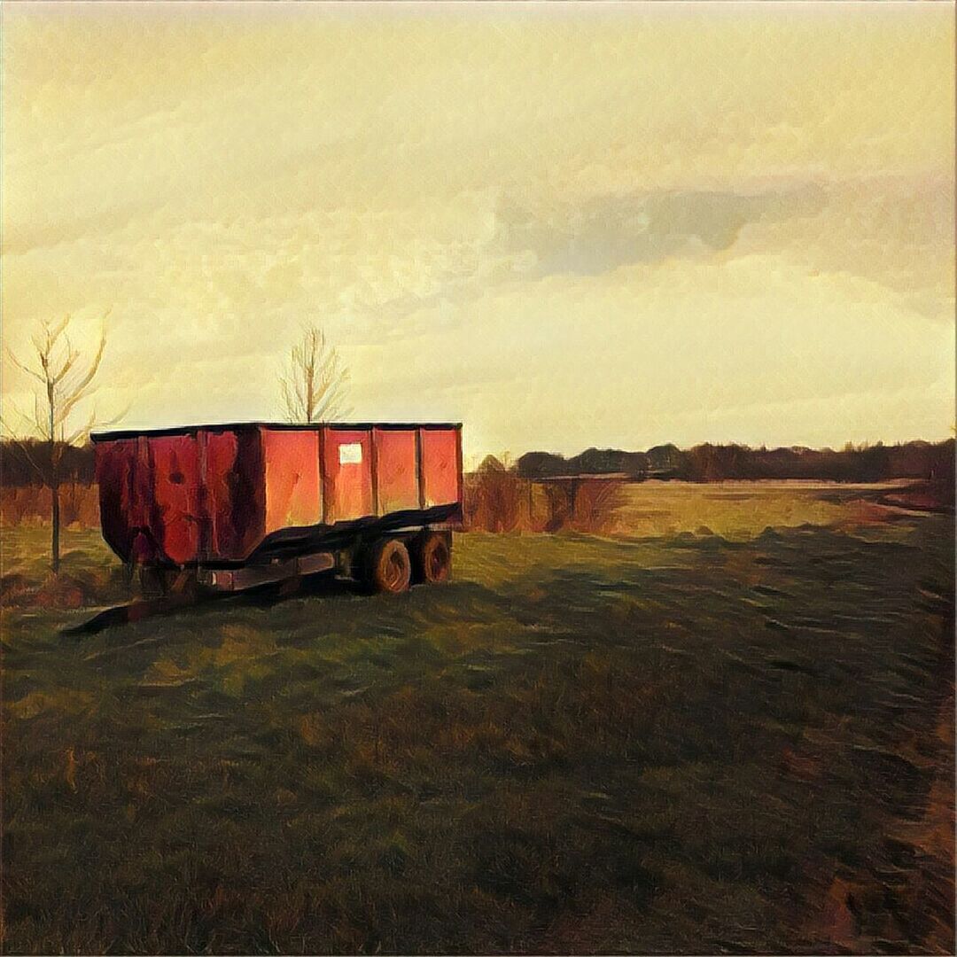 BARN ON FIELD AGAINST SKY