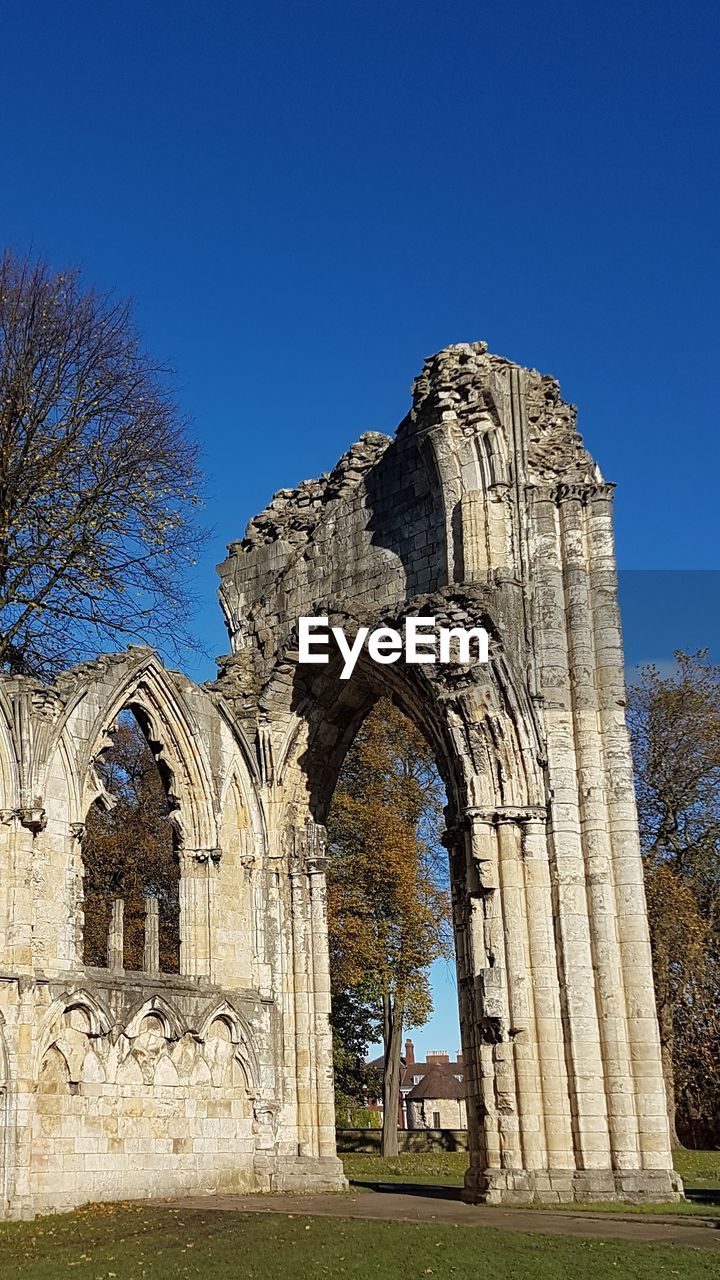 LOW ANGLE VIEW OF OLD TEMPLE AGAINST BLUE SKY