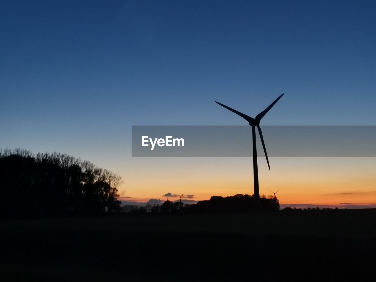 SILHOUETTE WINDMILL ON FIELD AGAINST SKY DURING SUNSET