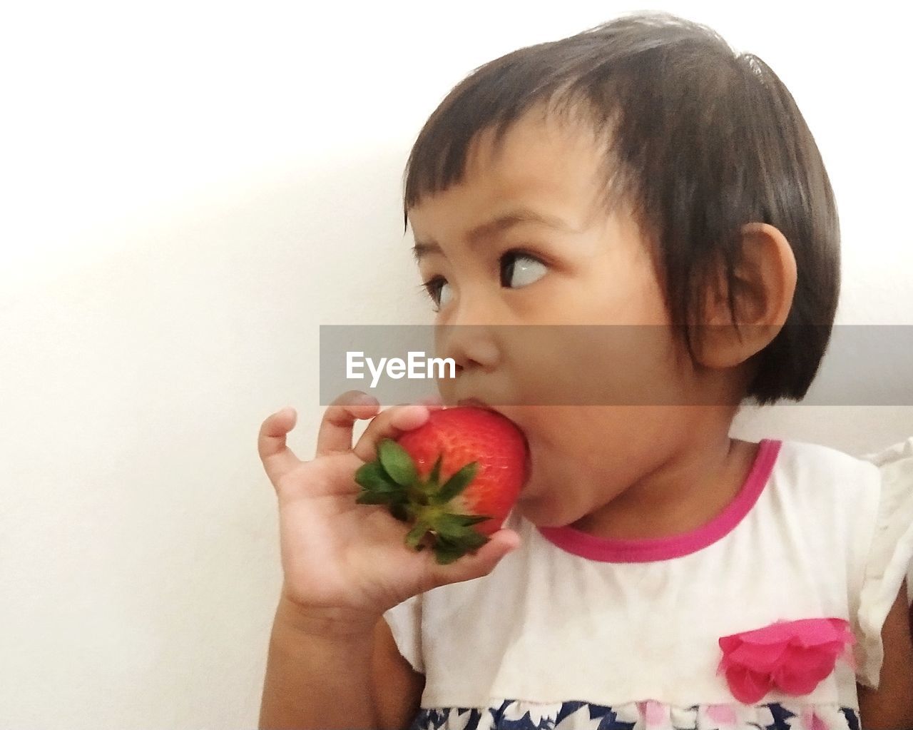 Close-up of girl eating strawberry