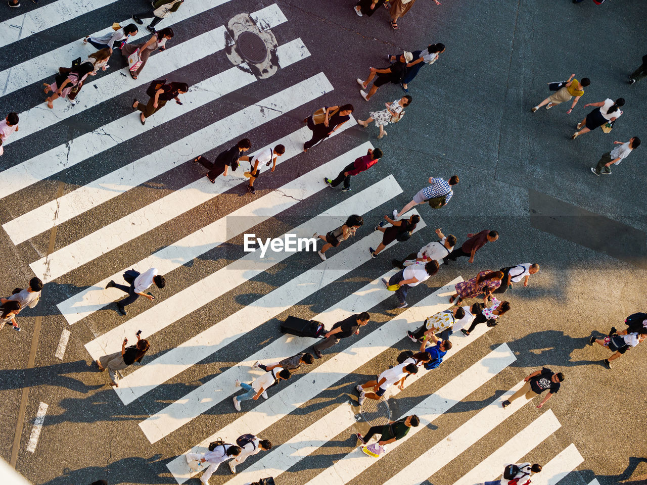 HIGH ANGLE VIEW OF PEOPLE CROSSING STREET
