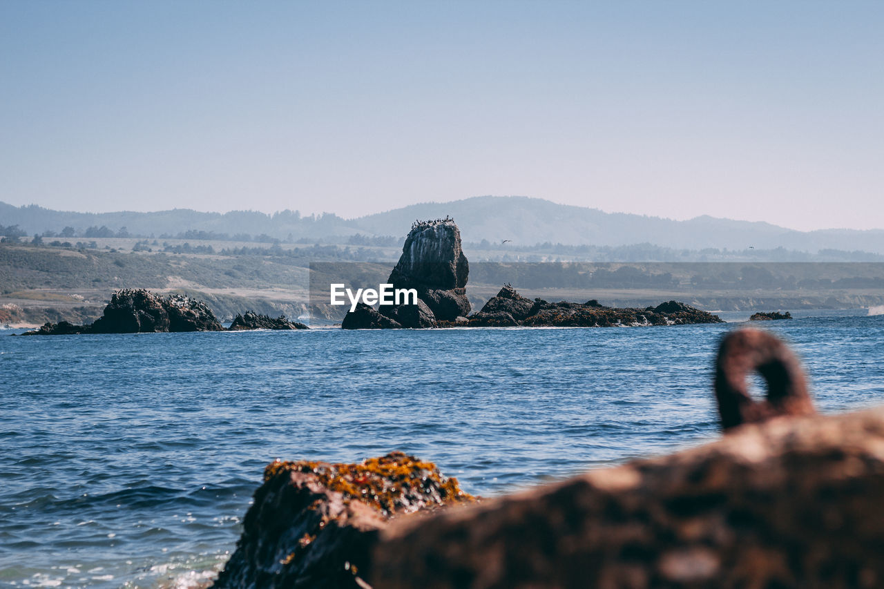 SCENIC VIEW OF SEA AND ROCK AGAINST SKY