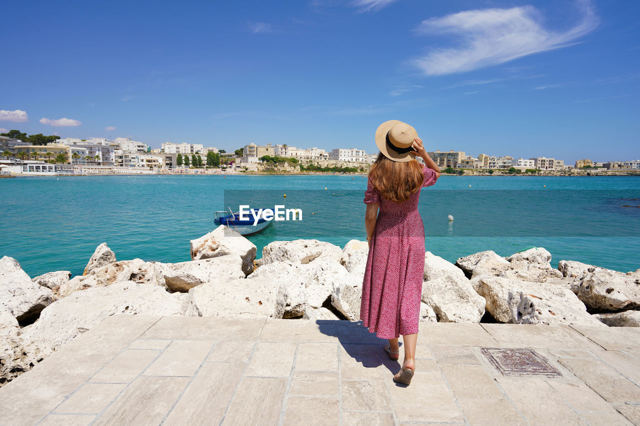 Rear view of woman looking at sea against sky