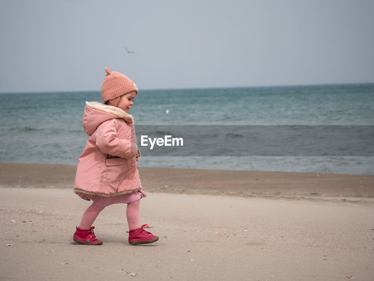 Low section of woman standing at beach