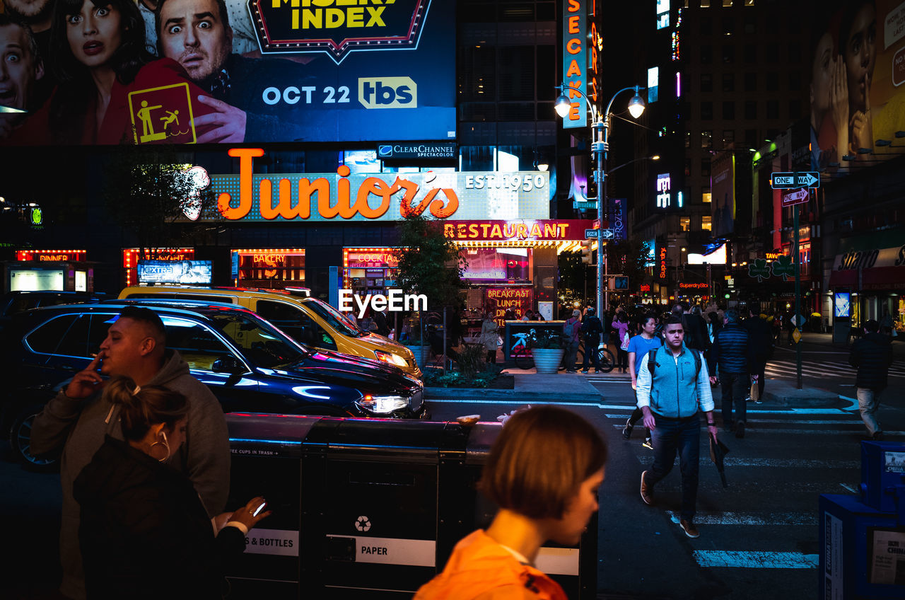 PEOPLE ON ILLUMINATED CITY STREET