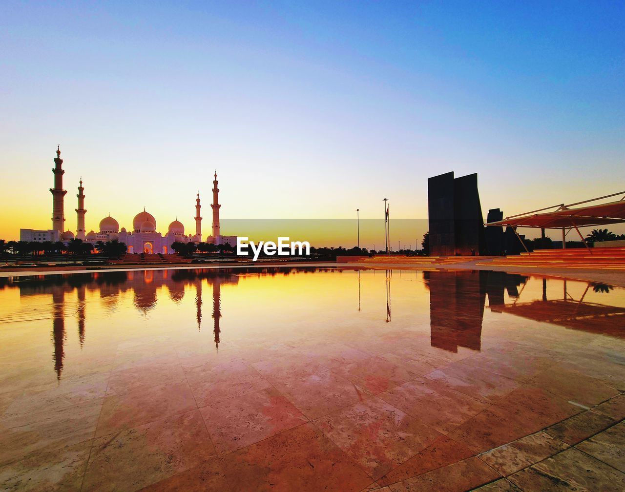 sky, architecture, water, reflection, built structure, sunset, dusk, evening, nature, horizon, building exterior, city, travel destinations, skyline, cityscape, no people, industry, twilight, outdoors, sea, travel, landscape, building, blue, clear sky, urban skyline, beauty in nature, landmark, transportation, business finance and industry