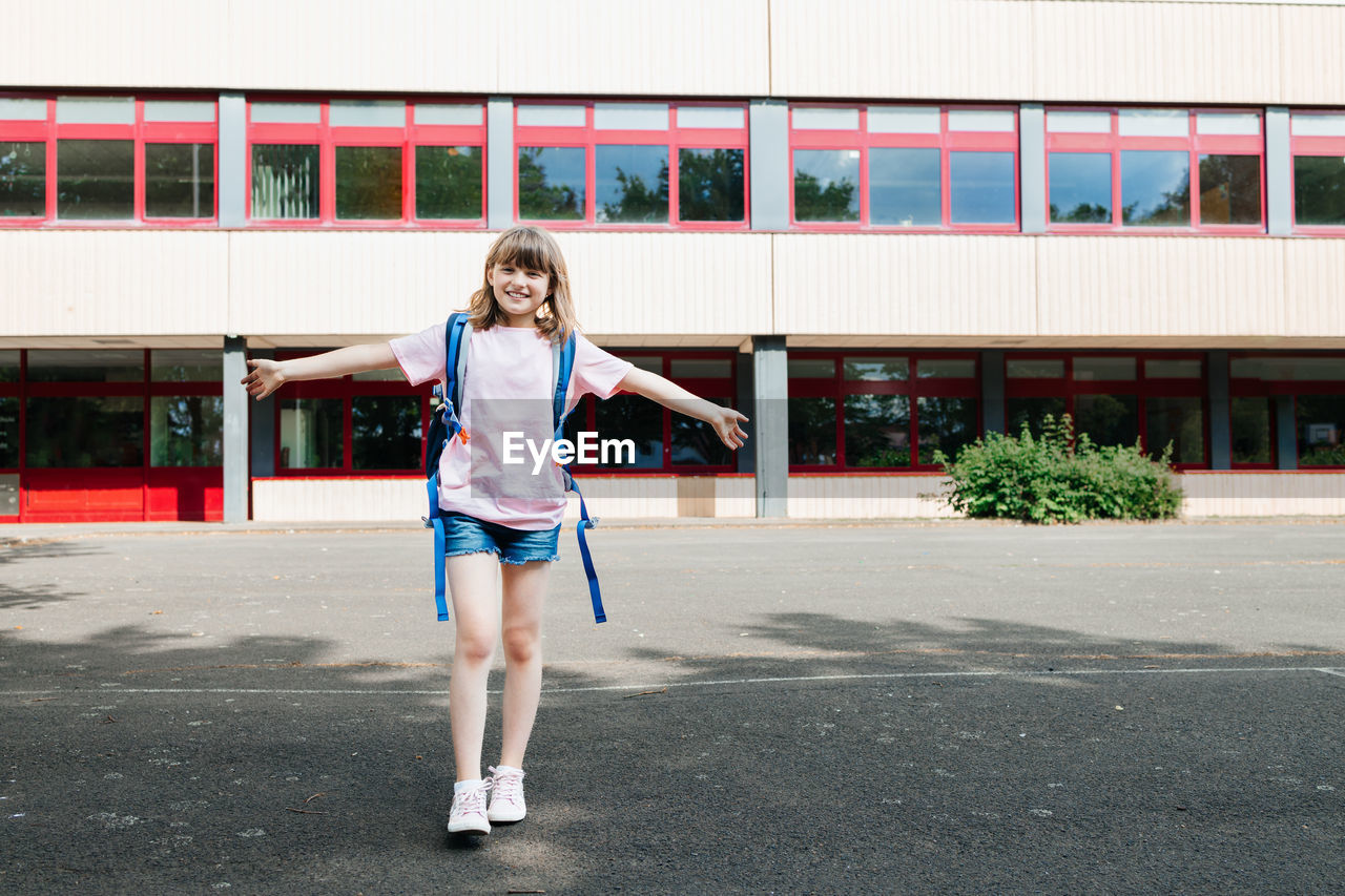 Portrait of a teenager schoolgirl in front of the school building. children begin the school year. 
