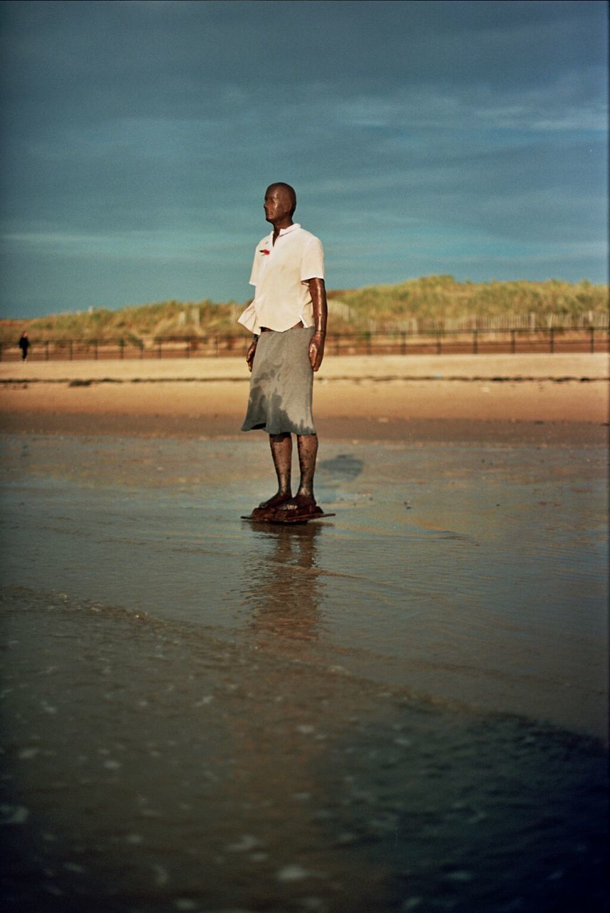 Mannequin in shirt and skirt on sandy beach