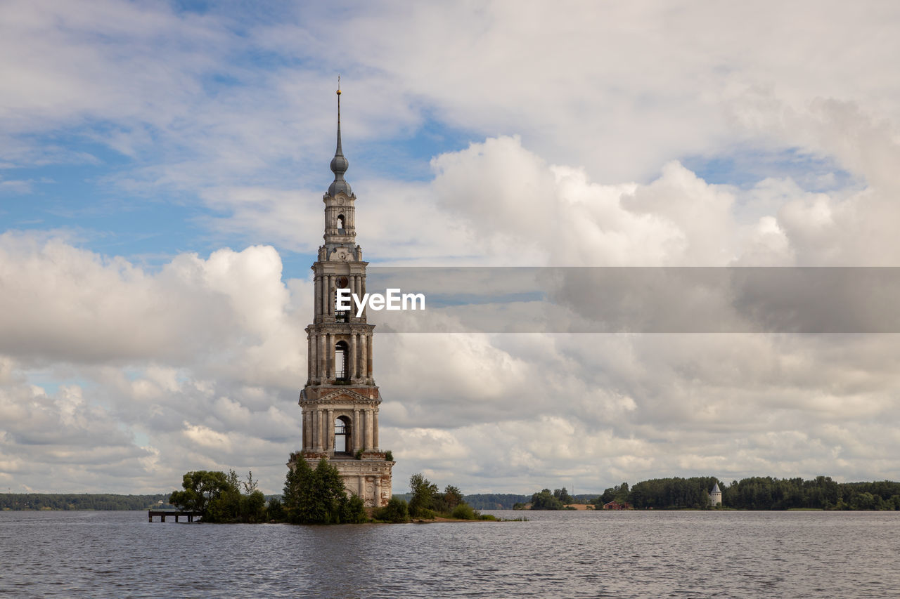 LIGHTHOUSE BY BUILDING AGAINST SKY