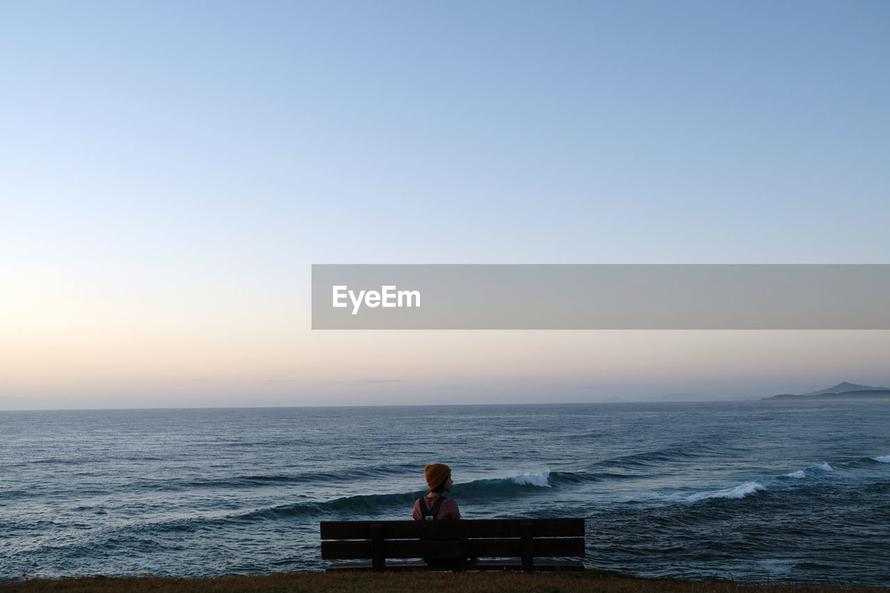 scenic view of sea against clear sky at sunset