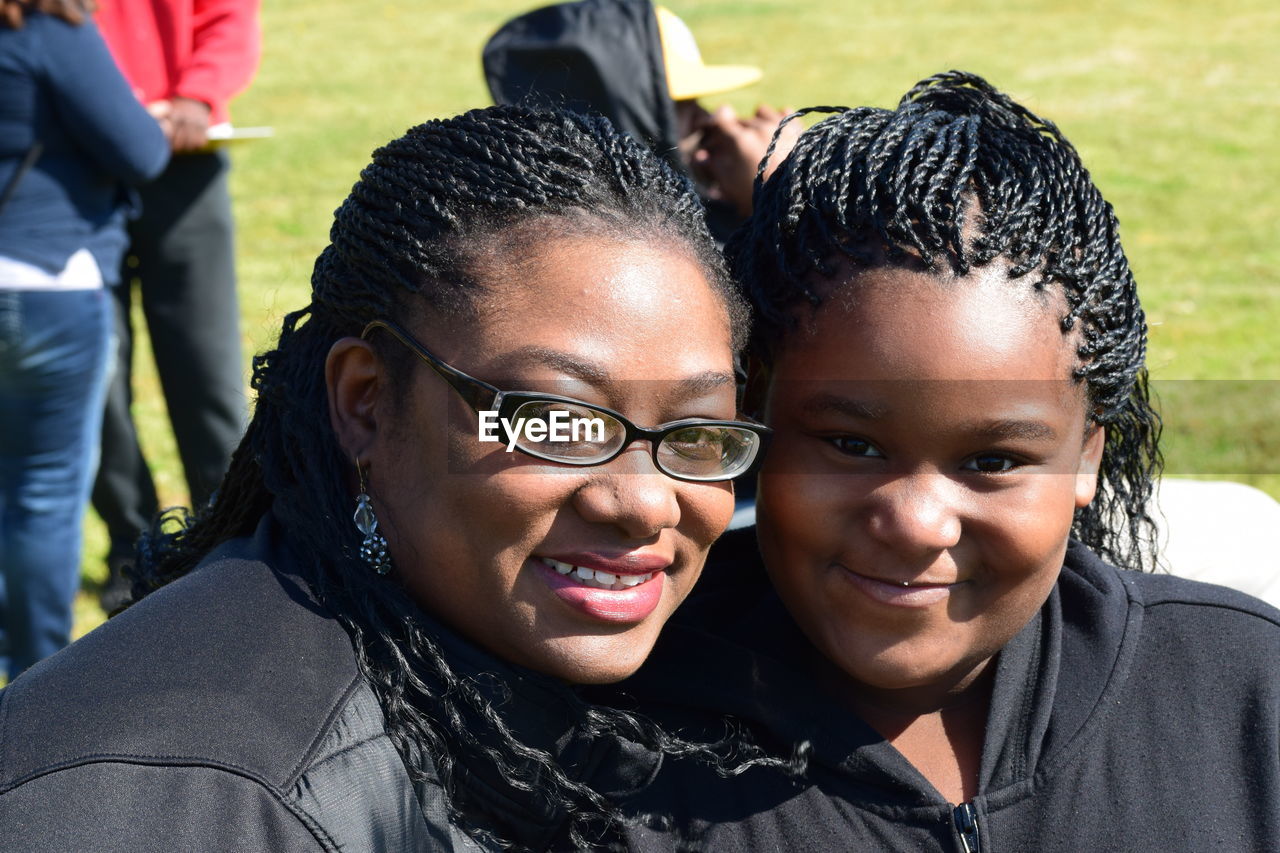 Portrait of mother and daughter smiling outdoors