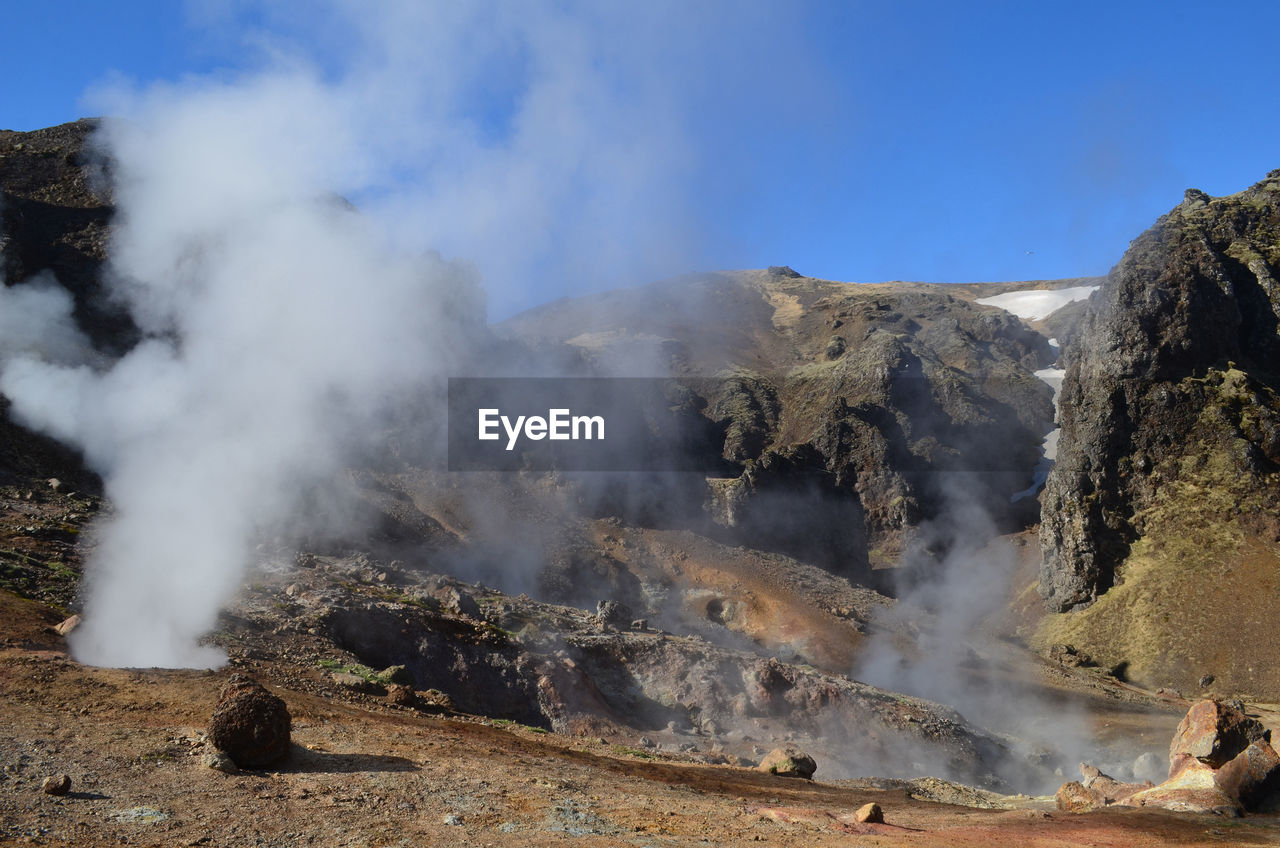 Steam and fumaroles rising from the rugged landscape of iceland.