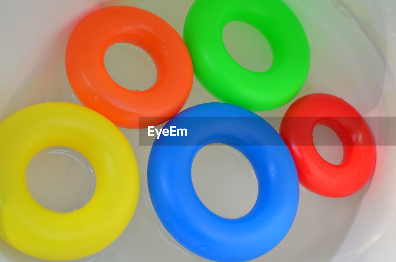 High angle view of colorful inflatable rings floating in pool