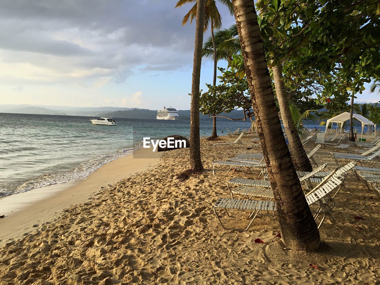 Scenic view of beach against cloudy sky