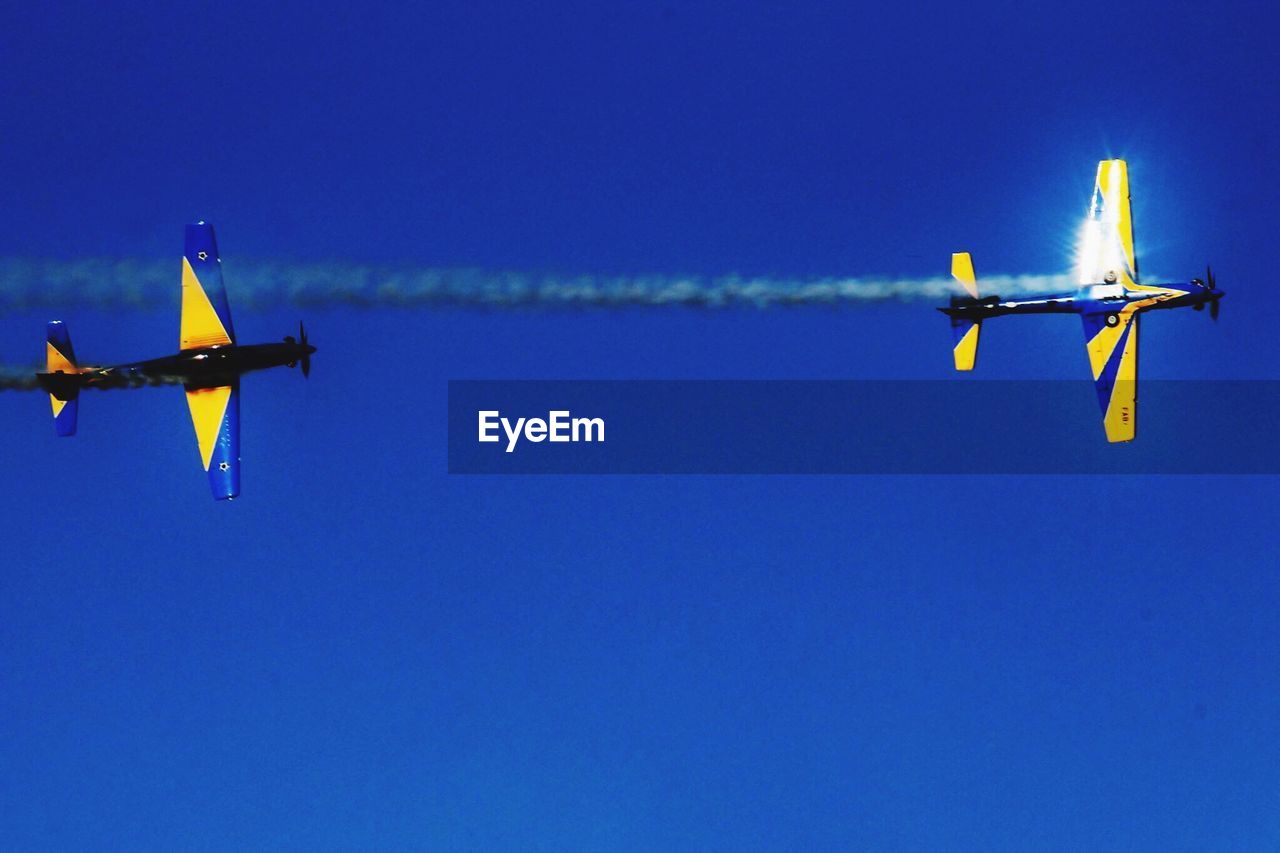 LOW ANGLE VIEW OF AIRPLANE AGAINST CLEAR BLUE SKY