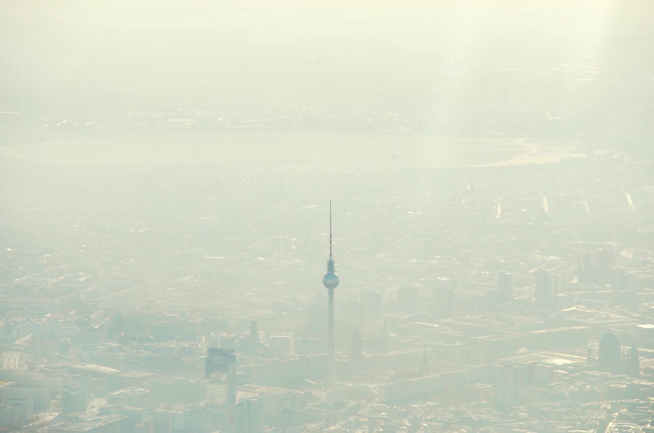 Aerial view of fernsehturm in city during foggy weather