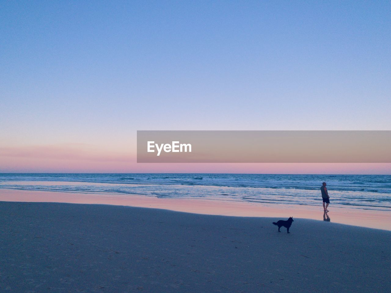 People walking on beach against clear sky