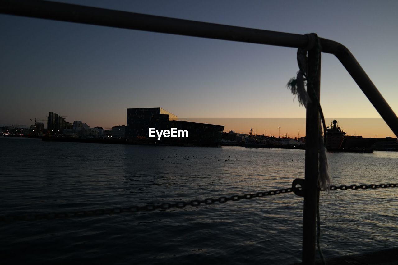 Silhouette buildings in distance with waterfront