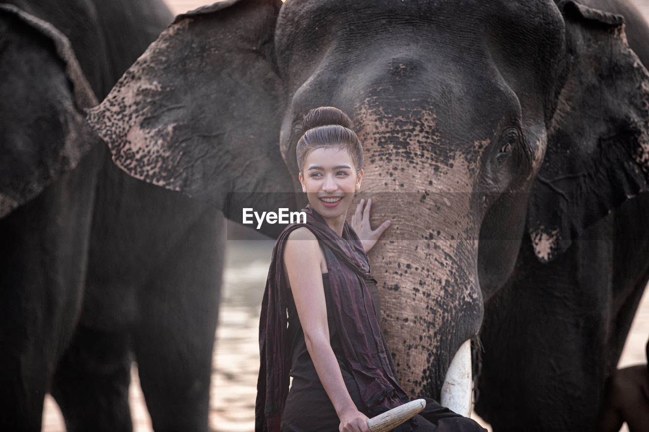 Woman looking away near elephant