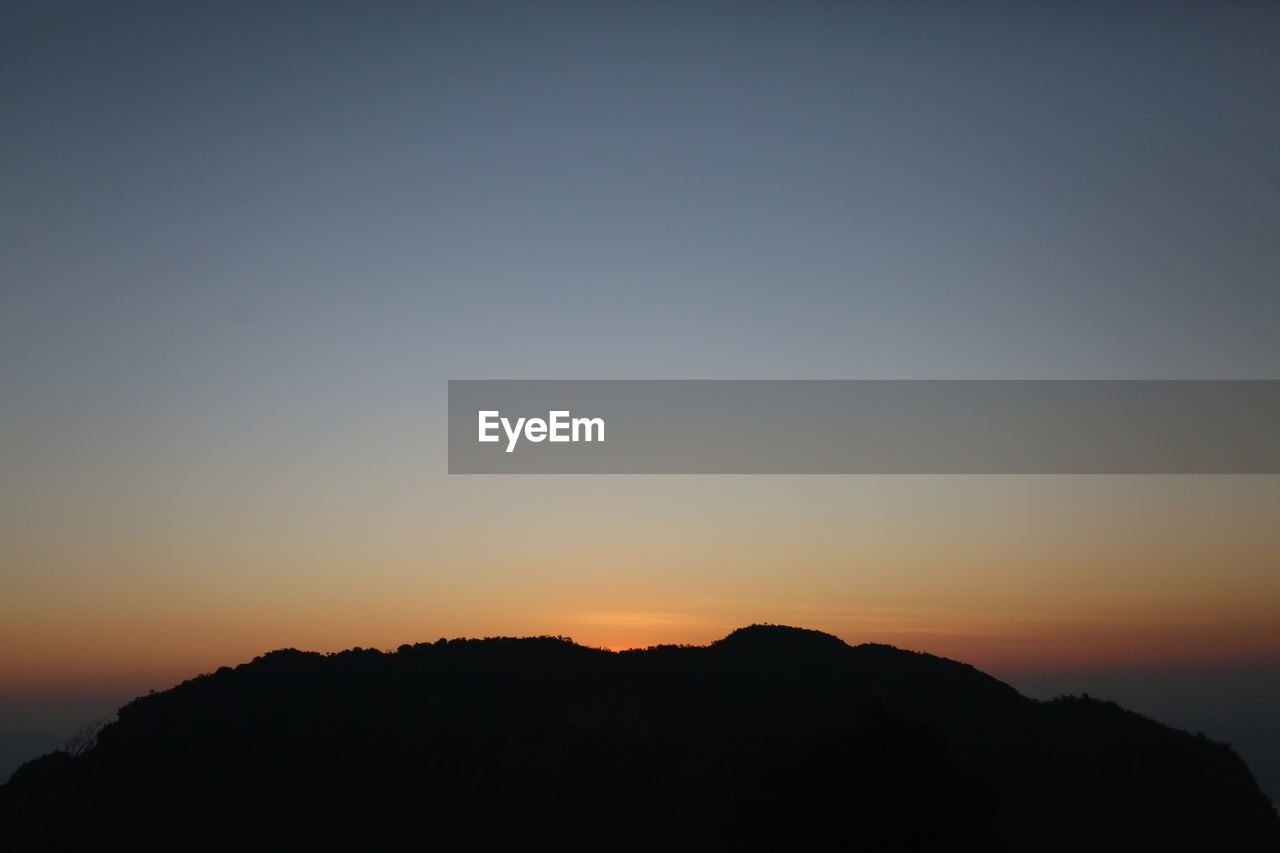 SILHOUETTE MOUNTAIN AGAINST CLEAR SKY AT SUNSET