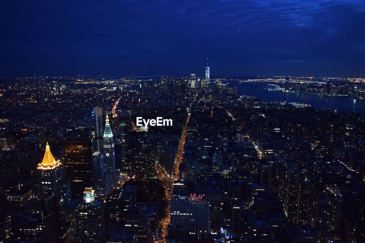 Aerial view of illuminated manhattan against sky at night