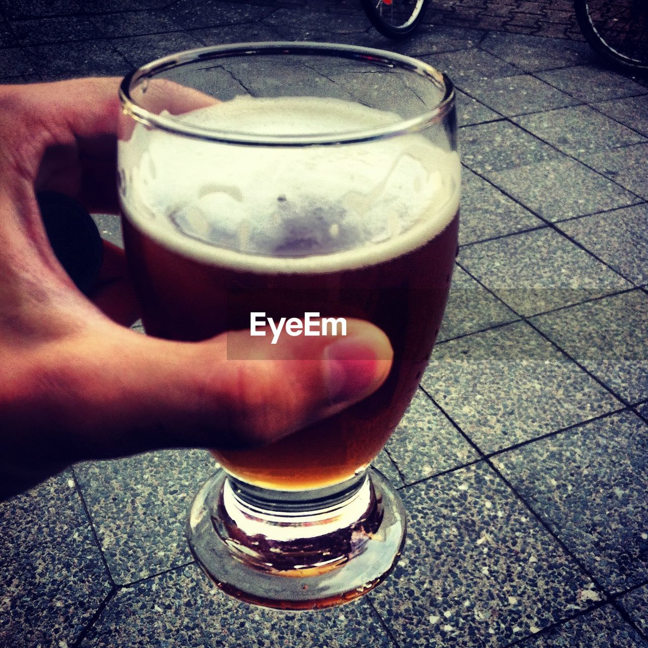 CLOSE-UP OF A HAND HOLDING BEER GLASS