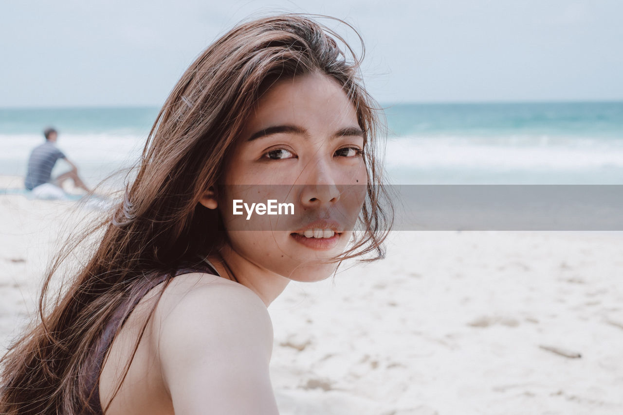 Portrait of mid adult woman standing at beach