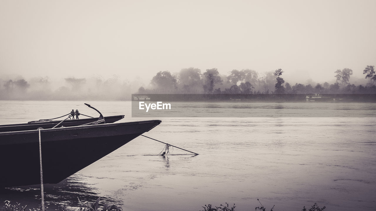 Silhouette boat in lake against clear sky